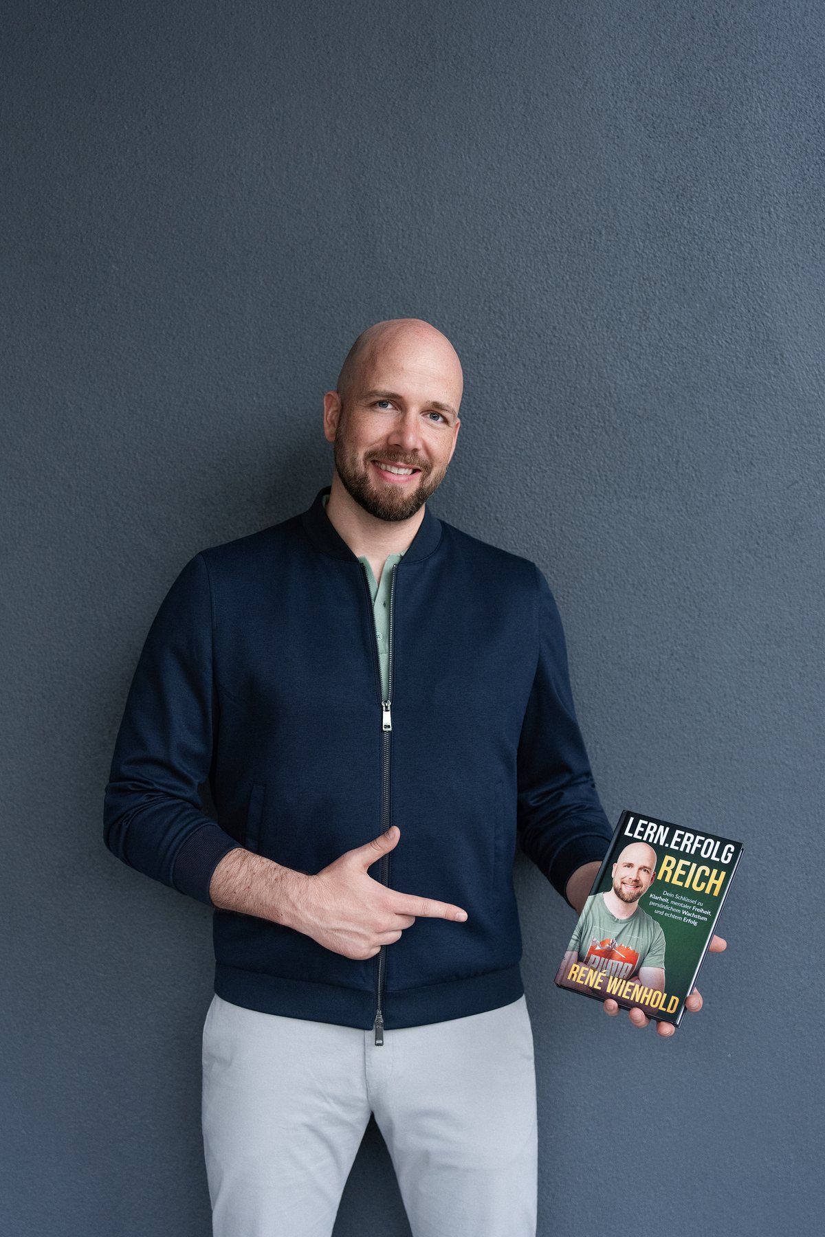 René Wienhold hält sein Buch Lern.Erfolg.Reich in der Hand